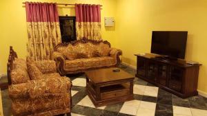 a living room with a couch and a flat screen tv at Golden Hill 34 in Cameron Highlands