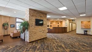 eine Lobby mit einer Ziegelwand und einem TV darauf in der Unterkunft Best Western Starlite Village in Fort Dodge