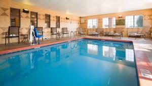 a pool with chairs and tables in a hotel room at Best Western J. C. Inn in Junction City