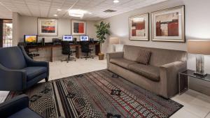 a living room with a couch and chairs and a desk at The Hotel at Dayton South in Dayton