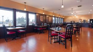 a dining room with tables and chairs and windows at Best Western Northgate in Nanaimo