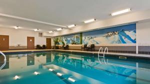 a swimming pool in a hotel with a mountain mural at Best Western Mountainview Inn in Golden