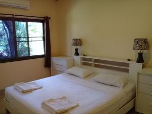 una camera da letto con un letto bianco con due asciugamani di Bootshaus a Ko Lanta