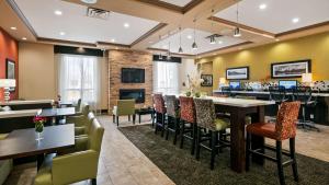 a restaurant with tables and chairs and a fireplace at Best Western Pacific Inn in Vernon