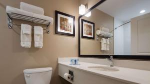 a bathroom with a toilet, sink and mirror at Best Western Plus Merritt Hotel in Merritt