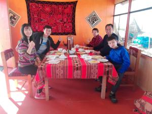 a group of people sitting around a table at Titicaca Aruntawi Lodge Peru in Puno