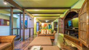 a living room with a couch and a tv at CELADON Holiday House in Palm Cove