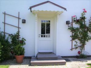 ニーブルムにあるHausteil Webstube Föhrの白い扉とポーチのある白い家