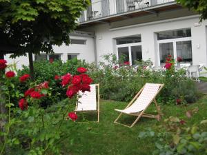 two lawn chairs sitting in the grass next to flowers at City Hotel in Linz