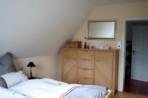 ニーブルムにあるHausteil Webstube Föhrのベッドルーム1室(ベッド1台、鏡付きドレッサー付)