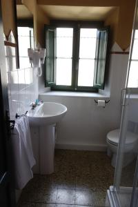 a bathroom with a sink and a toilet and a window at B&B Casale Dorando in Barga