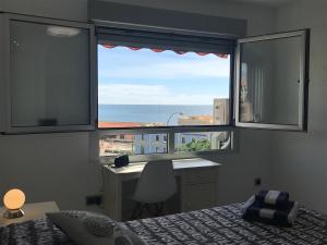 een slaapkamer met een bed, een bureau en een raam bij Las Brisas Del Mediterráneo in Alicante