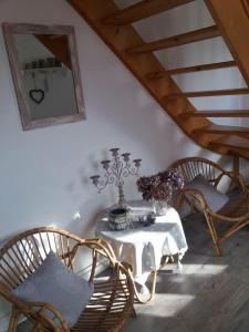Habitación con mesa con sillas y espejo. en Le Coq En Pate, en Péronne
