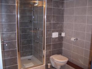 ein Bad mit einer Dusche und einem WC. in der Unterkunft The Originals City, Le Mas de Grille, Montpellier Sud (Qualys-Hotel) in Saint-Jean-de-Védas