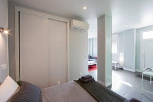 a living room with a bed and a sliding glass door at WindRose 2 in Madrid