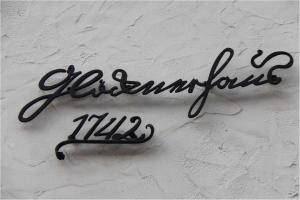 a sign for a restaurant on a white wall at Ferienhaus Gloecknerhaus in Michelstadt