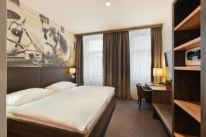 a hotel room with a bed and a desk at Hotel Lucia in Vienna