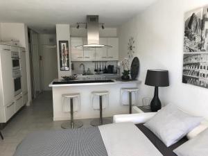 uma cozinha branca com uma cama e uma ilha de cozinha em Les Hameaux em Bandol