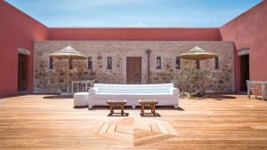 a living room with a couch and two tables and umbrellas at Faro Capo Spartivento in Chia