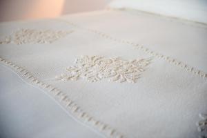 a close up of the embroidery on a white bedspread at Faro Capo Spartivento in Chia