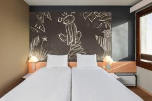 a bedroom with two beds and a wall with a cactus at ibis Charleroi Airport Brussels South in Charleroi +103 photos