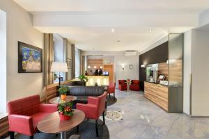 un vestíbulo de un hotel con sillas rojas y una mesa en Hotel Lucia, en Viena 36 fotos más