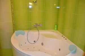 ドニプロにあるАпартаменты Летоの緑のタイル張りのバスルーム(バスタブ、シャワー付)が備わります。