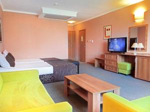 um quarto de hotel com uma cama e uma televisão em Hotel Real em Plovdiv
