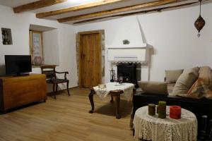a living room with a couch and a fireplace at Linos Traditional Cottage in Theológos