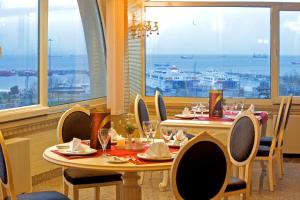 a dining room with a table and chairs and windows at Marmaray Hotel in Istanbul