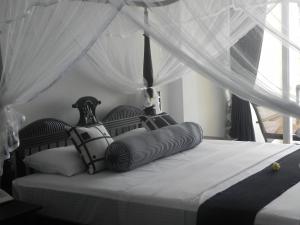 a bedroom with a bed with a canopy at Amanda Beach Villas in Unawatuna