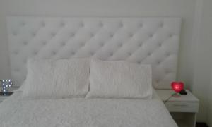 1 cama con cabecero blanco y un corazón rojo sobre una mesa en Edificio California en Centro Historico, en Lima