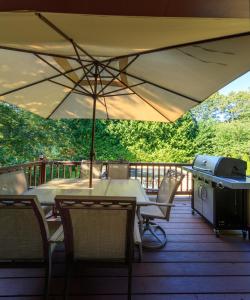 una mesa y sillas en una terraza con sombrilla en Nice 4bdr all Q size,IG Pool,Billiard, en Hampton Bays