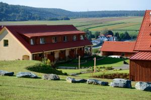 a house with a red roof on a hill with rocks at JUFA Hotel Neutal in Neutal