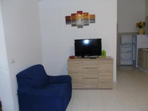 サンタ・テレーザ・ガッルーラにあるCasa Eleonoraのリビングルーム(青い椅子、テレビ付)