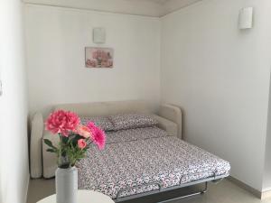 a small bedroom with a bed and a vase with flowers at B&B Bari Old Town in Bari