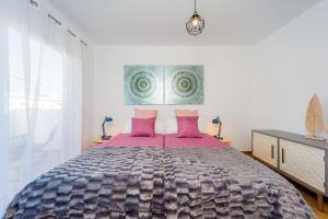 トレビエハにあるApartamentos El Abueloのベッドルーム1室(ピンクの枕が付いた大型ベッド1台付)