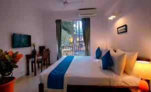 a hotel room with a bed and a window at Treehouse Blue Hotel & Serviced Apartments in Majorda