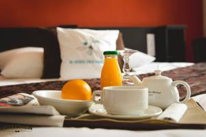 una mesa con una naranja y una botella de zumo de naranja en La Croix Verte - Le Relais des Moulins, en Bain-de-Bretagne