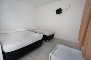 ein Zimmer mit zwei Betten und einem Waschbecken in der Unterkunft Hotel Marina Torrano in Trindade