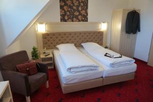 ein Hotelzimmer mit einem Bett und einem Stuhl in der Unterkunft Hotel Rappen Rothenburg ob der Tauber in Rothenburg ob der Tauber
