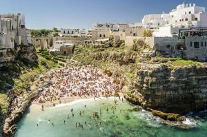 a group of people on a beach in the water at La Dimora del Gelso Rosso in Polignano a Mare