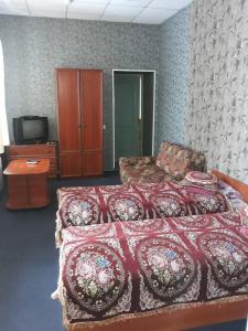 ポルタヴァにあるEuroLux Hotelのベッドルーム(ベッド1台、ソファ、テレビ付)