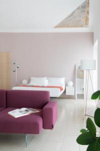 una camera con un divano viola e un letto di Brera Apartments in Moscova a Milano