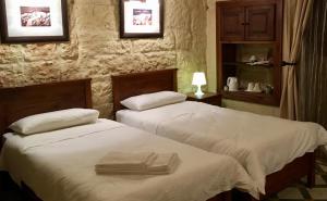 two beds in a hotel room with towels on them at Xemx in Qala