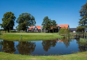 una casa en un campo de golf con un estanque en OnlySleep Oksebrovej, en Slagelse