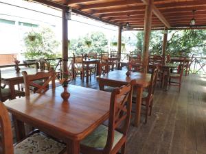 a restaurant with wooden tables and wooden chairs at Hotel Mango Garden in Kandy