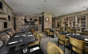 - un restaurant avec des tables et des chaises dans une salle dans l'établissement Le K2 Djola, à Courchevel