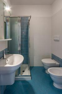 a bathroom with two sinks and a shower and a toilet at Residence Palazzo Mediterraneo in Tortoreto Lido