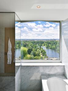 a bathroom with a large window with a view of a river at Royal Lancaster London in London